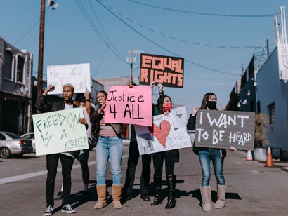 A group of protesters voice their discontent, mirroring the frustration felt by many who question why so many blindly follow trends without critical thought