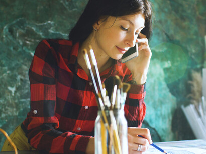A woman quietly sketching patterns in her journal