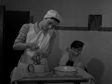 Practicante de enfermería Joyce Collier irriga el oído de un niño en el Departamento de Consultas Externas del Hospital St Helier. 1943