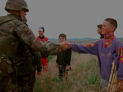 U.S. Marines interact with local boys near Camp Montieth in Gnjilane, Kosovo, on June 25, 1999, supporting NATO-led peacekeeping efforts as part of Operation Joint Guardian