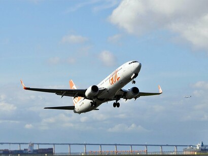 Um Boeing 737 da Gol aproxima-se da pista do Aeroporto Santos Dumont, enquanto outra aeronave aparece ao fundo. A cena representa a consolidação de um modelo que, ao reduzir custos e tarifas, ajudou a transformar o transporte aéreo em um serviço mais acessível a diferentes públicos