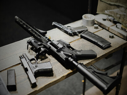 A set of guns resting on a table, symbolizing the main instruments behind the vague political promises of peace