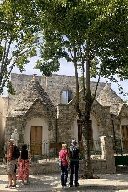 People looking at the buildings in Alberobello, Italy 