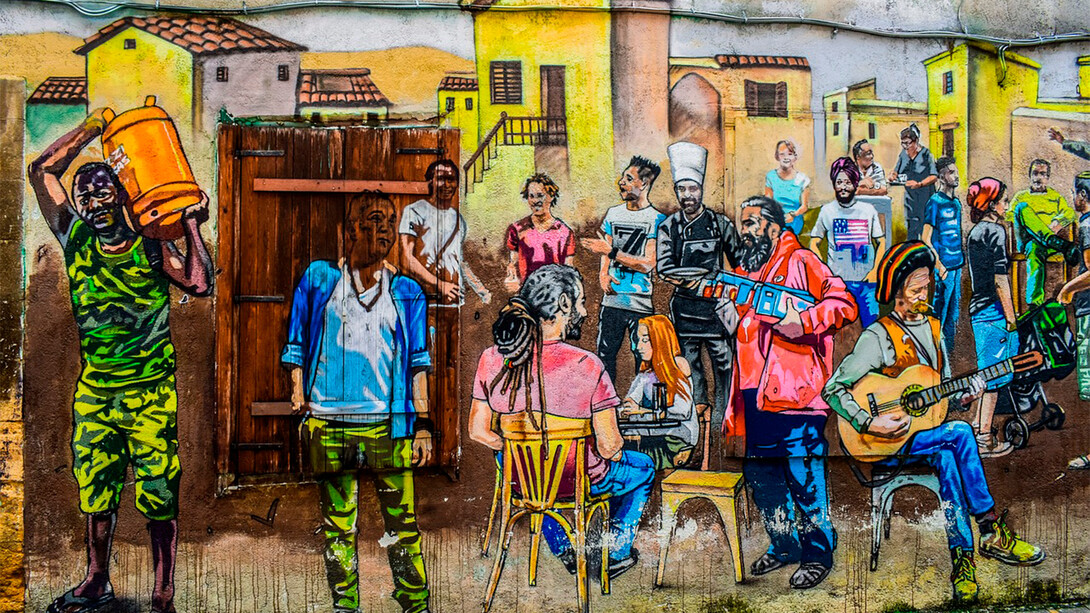 Grafite de pessoas de diferentes nacionalidades em um mesmo espaço. Mais africanos na Europa, mais latinos em África, mais americanos na Ásia, mais asiáticos em África, mais europeus na Austrália