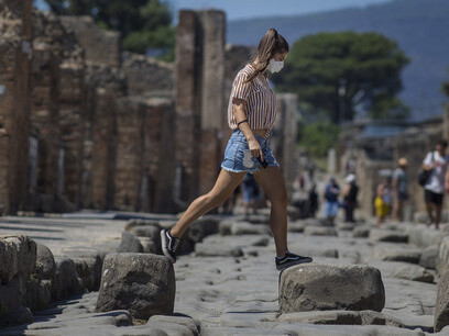 9.	Pompei, 19 agosto 2020, Giovane ragazza con mascherina salta sulle antiche pietre dopo la reapertura ai siti turistici.  (Pablo Esparza/Heraldo de México)