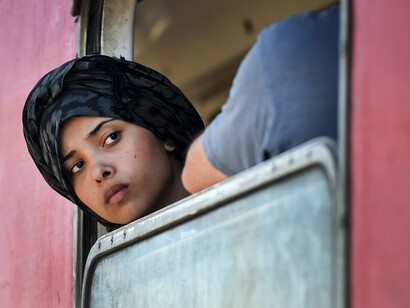 Un joven inmigrante se asoma por la ventanilla de un tren