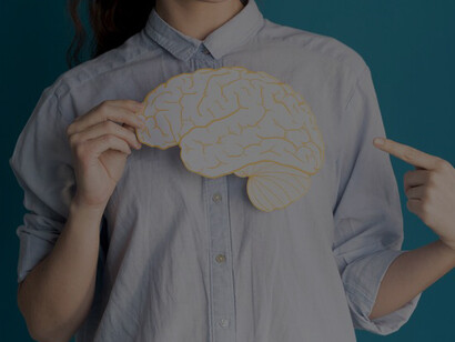 A close-up of a person pointing at a paper brain highlights key concepts related to brain health and stroke