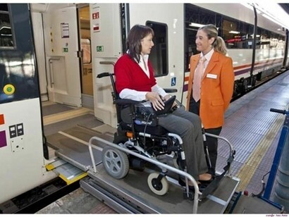 Una mujer baja del tren con su silla de ruedas por una rampa especial habilitada a tal efecto
