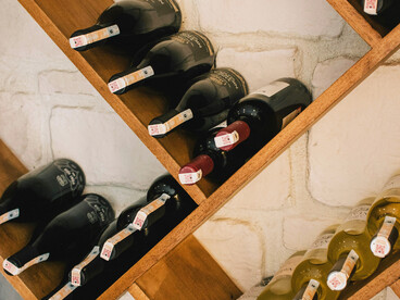 Wine bottles arranged on a brown wooden shelf
