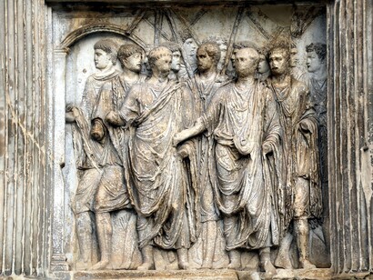 La struttura è sormontata da un attico su cui originariamente era collocata una statua di Traiano, oggi scomparsa, ma che testimoniava l'importanza e la grandezza dell'imperatore. Dettaglio dei rilievi: Traiano è accolto dai Geni del Popolo Romano, del Senato e dell'Ordine Equestre. Arco di Traiano, Benevento, Italia



