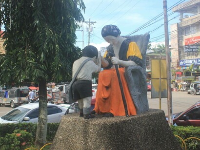 Statue of a child offering mano gesture to elder woman in Iriga, Philippines