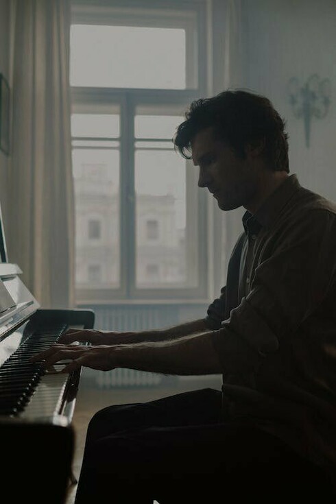 Un uomo si esercita al pianoforte con molta concentrazione