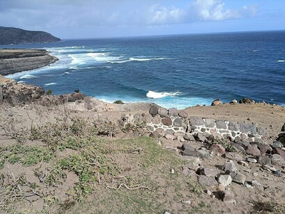 The rugged coastline of St. Eustatius, where waves crash against volcanic cliffs shaped by centuries of history
