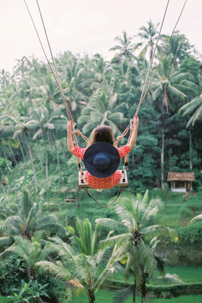 A woman enjoying a swing ride with a view of the tropical forest in Ubud, Bali, Indonesia