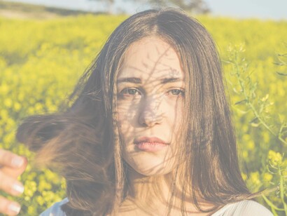 Portrait of a woman in a field: her eyes don't lie when it comes to achieving self-love and most importantly feeling it when it seems like a distant memory 