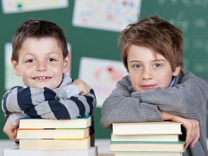 Dos niños apoyados sobre libros