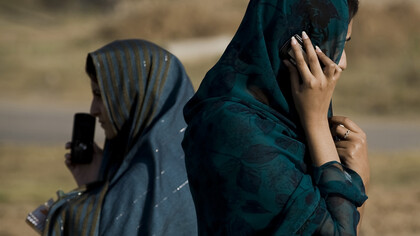 Mujeres afganas hablando con sus teléfonos móviles