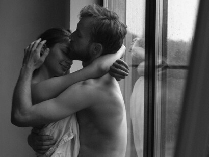 A black-and-white embrace captured in soft light, where love lingers between warmth and reflection, mirroring the quiet intimacy woven through verses of longing