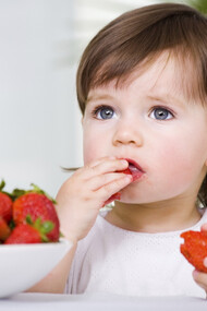 Una niña comiendo fresas