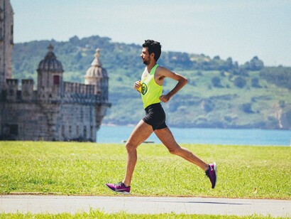 Jovem corre na pista em dia ensolarado