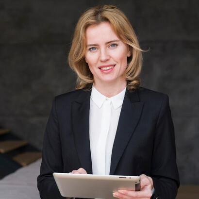 A focused businesswoman working on a tablet, highlighting female entrepreneurship, the presence of women in business, and their contribution to driving economic growth