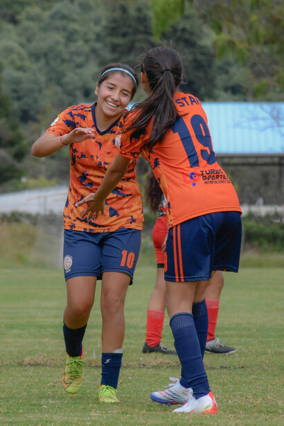 Compañeras de equipo saludándose. El deporte genera el concepto de trabajar en equipo