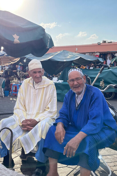 À Jemaa el-Fna (Marrakech, Maroc), on vient parfois pour écouter le silence entre deux conversations. Deux hommes assis sous le soleil de la ville ocre, comme deux gardiens tranquilles d’un temps qui refuse de disparaître