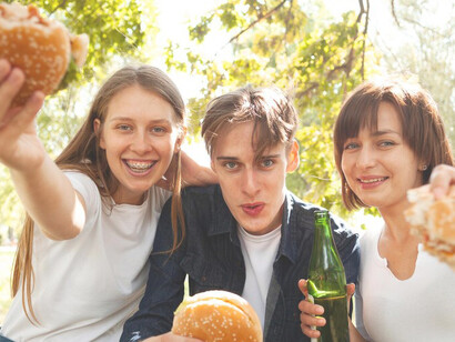The fun with friends enjoying burgers and beer at the park, snapping selfies in the sunshine