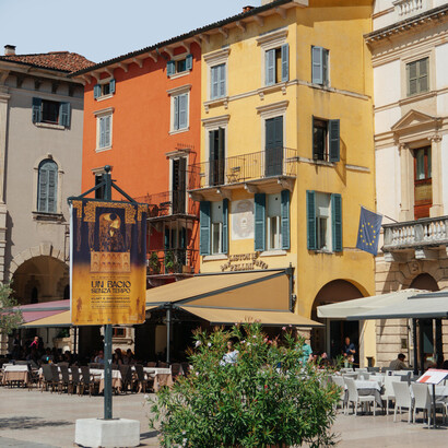 A lively street scene in Verona, Italy, surrounded by colorful historic buildings