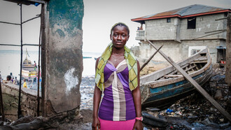 A young woman in a low-income area faces the stark reality of global economic imbalance, where the resources we have could end poverty if only we adjusted our social and political systems