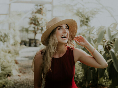 Mujer en un vestido recorre recorre un vivero sola y feliz. Darse cariño es muy importante