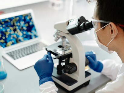 In a biotechnology lab, a researcher examines samples under a microscope, representing innovations in sustainable agriculture and the future of food