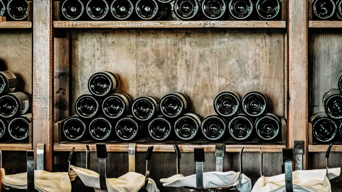 The sophisticated allure of black wine bottles elegantly displayed on a rustic wooden shelf, adding a touch of timeless charm to your wine collection