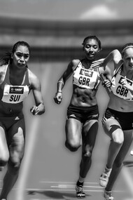Women athletes running in a daytime race as fans cheer from the stadium