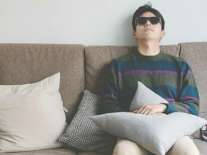 Man laying on a couch with sunglasses