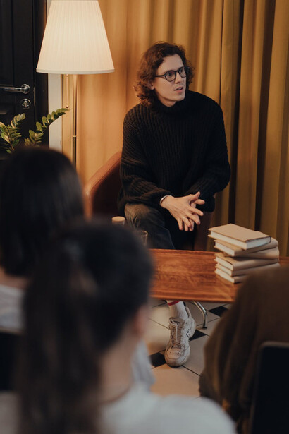 Ragazzo ascolta e interloquisce con le persone sedute di fronte a lui