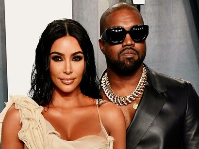 Kim Kardashian smiling while Kanye West is looking serious during their red carpet visit at the Vanity Fair Oscar Party in Beverly Hills, USA