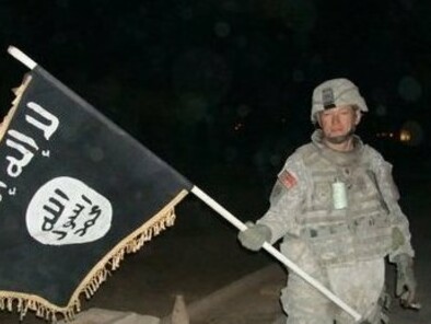 Un soldado americano con una bandera del Estado islámico