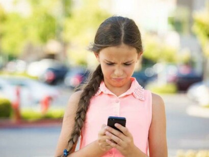 Una adolescente mirando su móvil