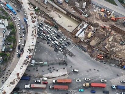 Traffic weaving around a construction site, reflecting the delays and inefficiencies that often undermine public confidence in infrastructure projects