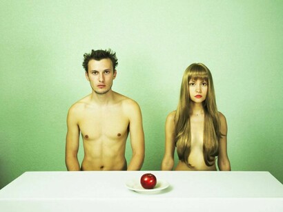 Una pareja desnuda sentada a la mesa