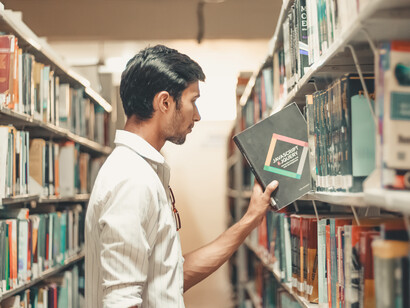 Estudiante toma un libro de la biblioteca escolar