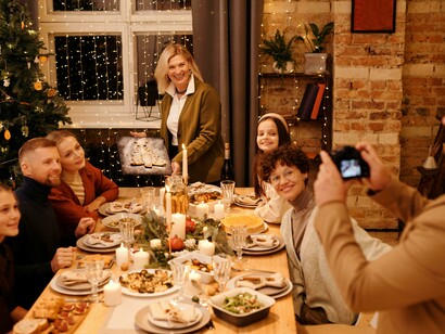A family celebrating Christmas dinner, capturing the moment with a selfie