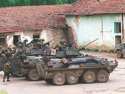 Marines from the 2nd Light Armored Reconnaissance Battalion conduct urban patrols in Zegra, Kosovo, aboard their LAV-25 vehicles in support of NATO's peacekeeping mission, Operation Joint Guardian