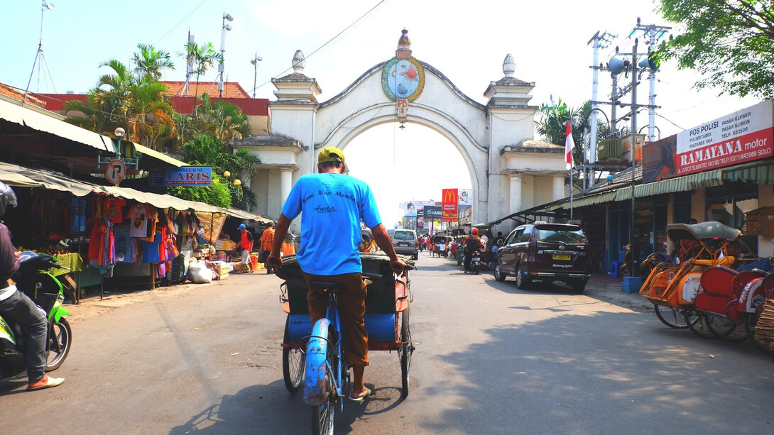 The vibrant streets of Solo, Indonesia, come alive with the hustle and bustle of tuk-tuks, motorcycles, and pedestrians weaving through colorful markets and local vendors