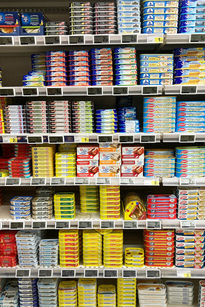 Neatly organized shelves filled with colorful canned fish products inside a busy French supermarket, Le Touquet, Hauts-de-France, France