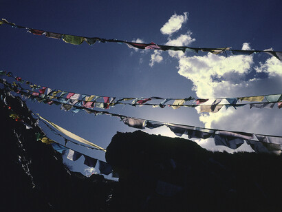 Marissa Roth, Prayer flags on a high pass overlooking Jalsa, a towering eleventh-century Buddha cut into the rock face, near Lhasa. September 2010. © Marissa Roth.
