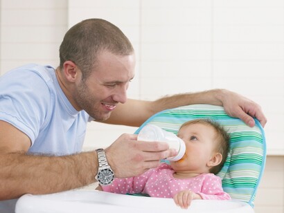 Un padre dando de comer a su hija
