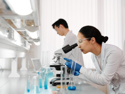 Two scientists looking at water samples under a microscope