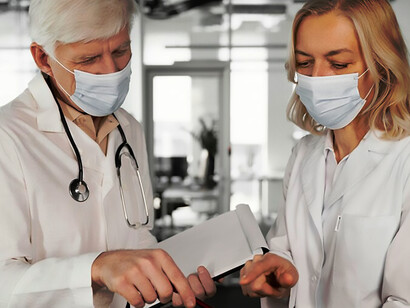 Medical professionals in masks discuss P4 medicine, underscoring personalized healthcare solutions